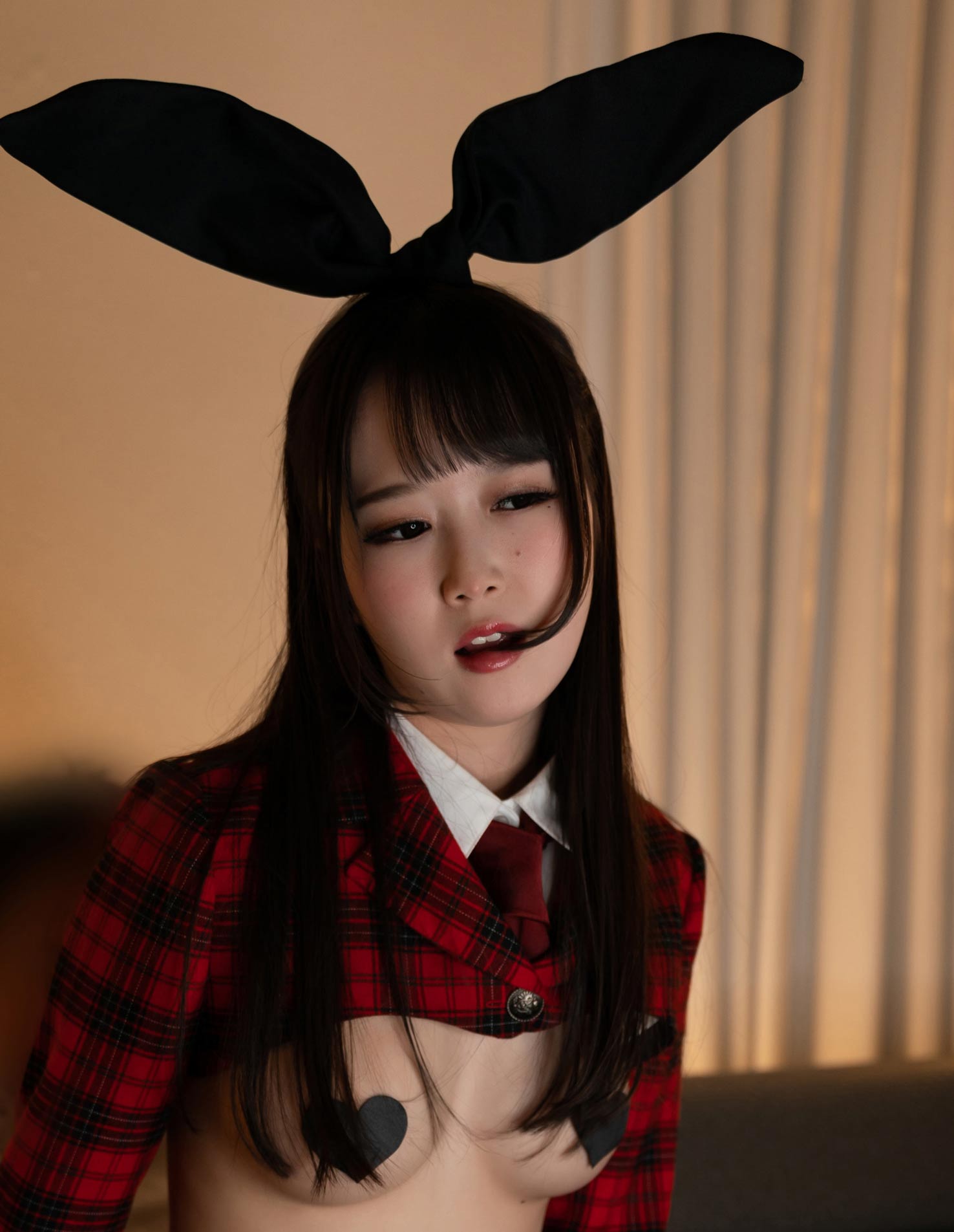Beautiful Ria Kurumi wears a Cosplay costume with Bunny ears, heart shaped pasties and a plaid jacket for Cospuri.