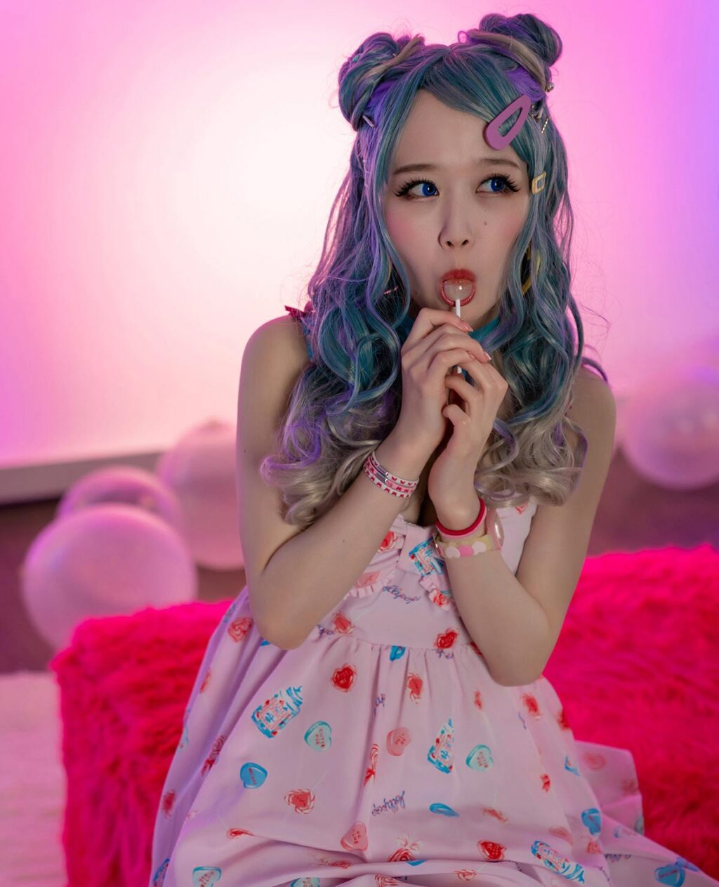 Wonderland Ria Kurumi as a Cosplay girl licking lollipop among pink balloons for Cospuri.